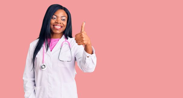 Młoda Afroamerykanka w stetoskopie wyglądająca na dumną, uśmiechnięta, robiąca gest z boku.  - Zdjęcie, obraz