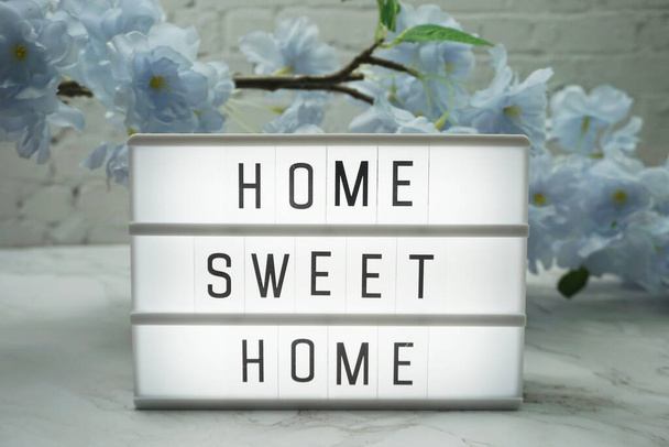Home Sweet Home Word in light box with flowers decoration - Foto, afbeelding