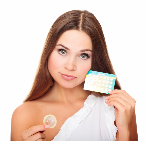 Красивая девушка с презервативом и противозачаточными таблетками
 - Фото, изображение