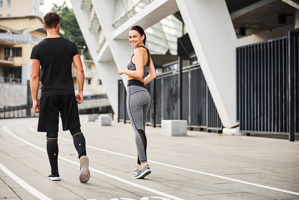 Happy young woman going jogging with boyfriend - Photo, Image