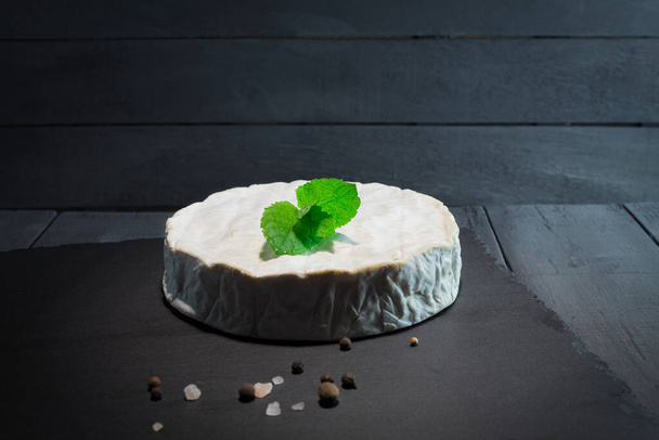 Foto de un queso camembert redondo. Primer plano de queso Camembert fresco y apetitoso - Foto, imagen