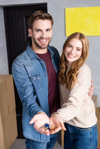potěšen muž a žena drží klíče v rukou, pohybující se koncept - Fotografie, Obrázek