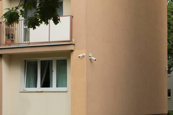 Kamery ochrony w budynku mieszkalnym. Dwie kamery na zewnątrz na rogu domu. System śledzenia wideo - Zdjęcie, obraz