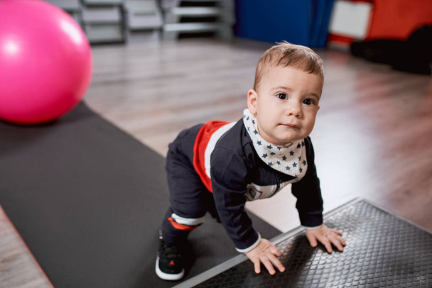 Toddler boy dressed in sportswear in gym - Zdjęcie, obraz