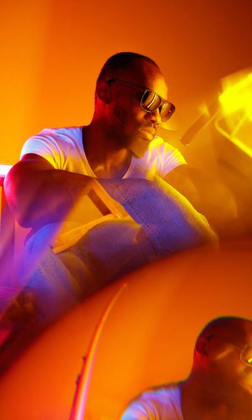 Cinematic portrait of handsome young man in neon lighted room, stylish musician - Fotó, kép