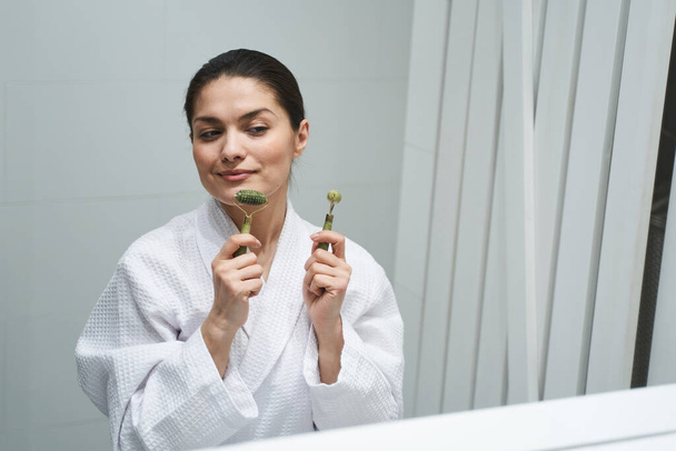 Pleased woman preparing for a facial massage - Фото, изображение