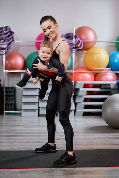 Woman playing with her child in the gym - Photo, image