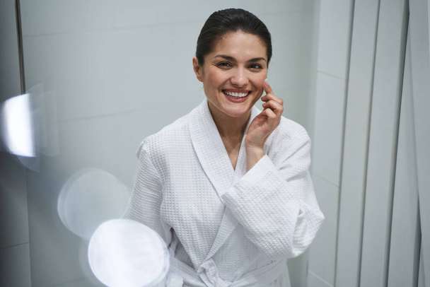 Female moisturizing the skin with a cosmetic product - Φωτογραφία, εικόνα