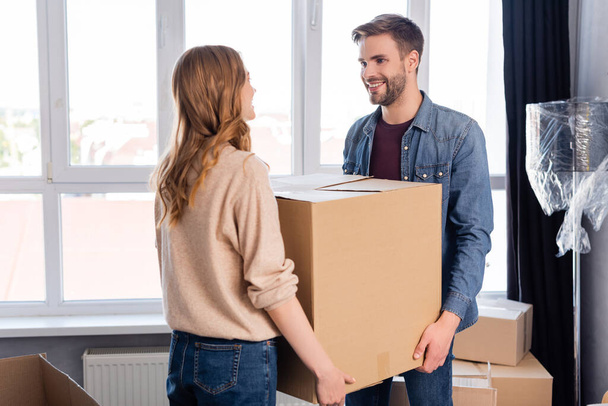 bearded man and woman holding carton box, moving concept - Zdjęcie, obraz