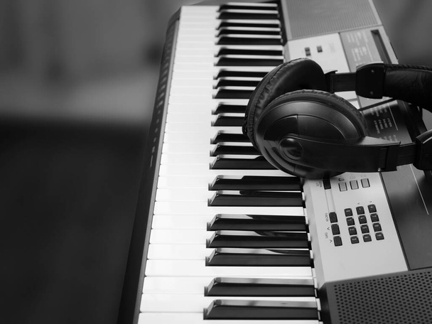 Headphones and black and white keys as background for text - Photo, Image