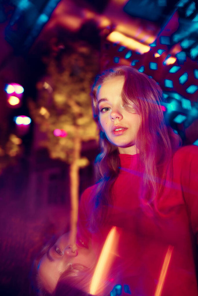 Cinematic portrait of handsome young woman in neon lighted room, stylish musician - Photo, Image