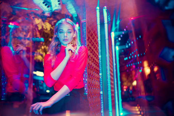 Cinematic portrait of handsome young woman in neon lighted room, stylish musician - Φωτογραφία, εικόνα