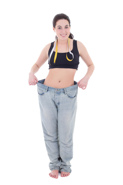 schöne schlanke Frau in großen Jeans isoliert auf weiss - Foto, Bild