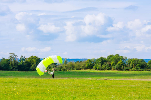 El paracaidista ha aterrizado en un campo de hierba. Salto en paracaídas. Paracaidismo. - Foto, imagen