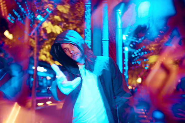 Cinematic portrait of handsome young man in neon lighted room, stylish musician - Φωτογραφία, εικόνα