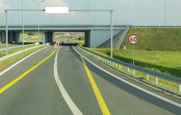 Ein Verkehrsschild auf einer Autobahn mit Tempolimit. Blick auf die Straße vom Auto aus. Straßen mit Markierungen und Verkehrsschildern - Foto, Bild