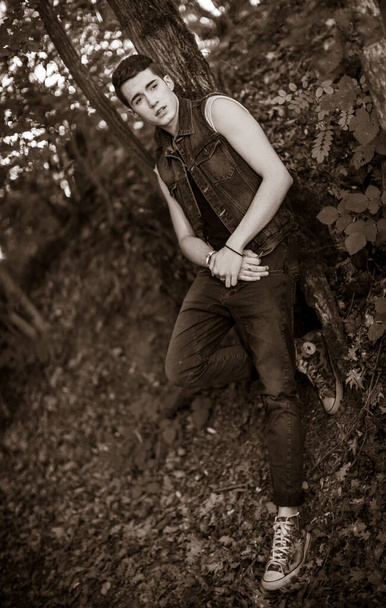 kaunis kaveri poseeraa ulkona farkkutakki metsässä - Valokuva, kuva