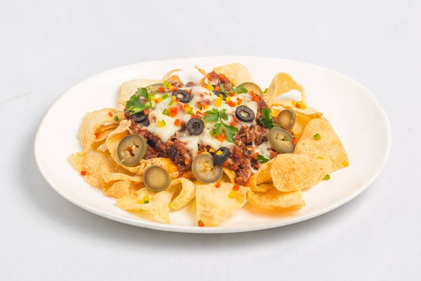 Mexikói híres étel fűszeres földi marhahús Nachos. Fűtött ropogós tortilla chips olvadt sajttal és jalapeno szolgált egy snack élelmiszer. - Fotó, kép