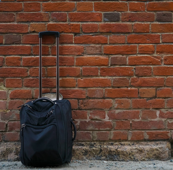Packed suitcases on red  brick wall background. empty copy space for inscription. - Фото, изображение