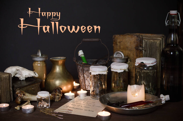 hátborzongató boszorkányok konyhája sok hozzávalóval egy szerelmi bájitalhoz és ősi hátborzongató üvegekkel, sötét, csak gyertyafényes halloweennel. - Fotó, kép