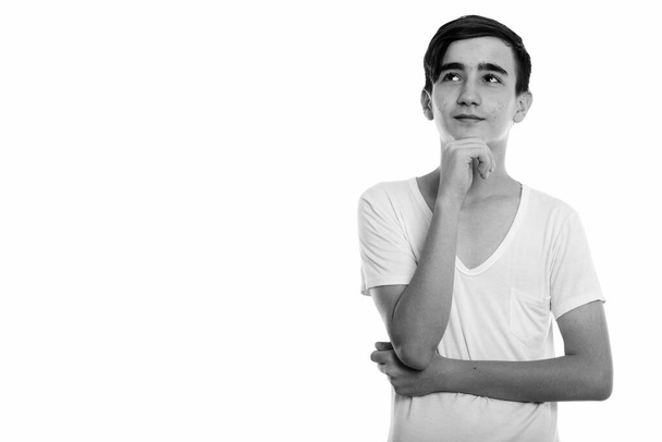 Studioaufnahme eines jungen gutaussehenden persischen Teenagers isoliert vor weißem Hintergrund in schwarz-weiß - Foto, Bild
