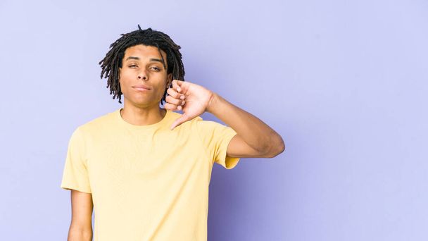 Jeune homme afro-américain rasta montrant un geste détestable, pouces baissés. Concept de désaccord. - Photo, image