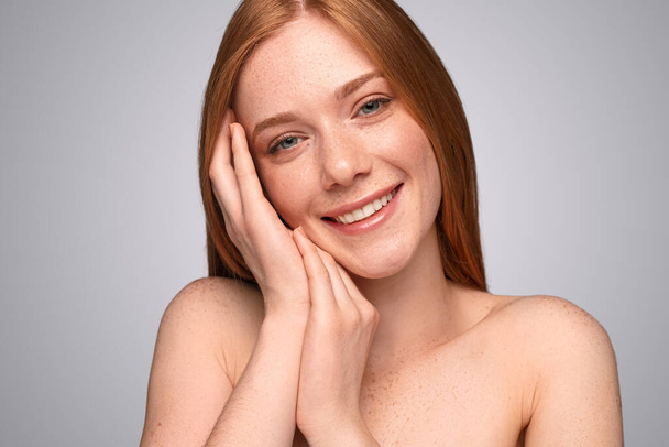 Delighted ginger woman touching face - Foto, imagen