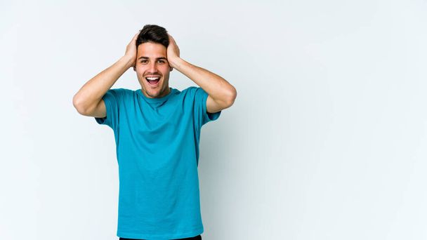 Young caucasian man isolated on white background screaming, very excited, passionate, satisfied with something. - Photo, Image