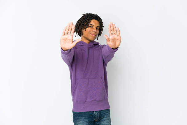 Молодий афроамериканець раста стоїть з розпростертою рукою і показує знак "Стоп", запобігаючи вам. - Фото, зображення