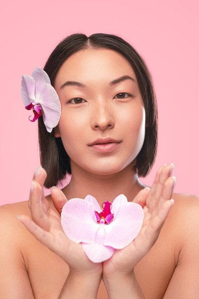 Asian model showing fresh flower - Foto, imagen