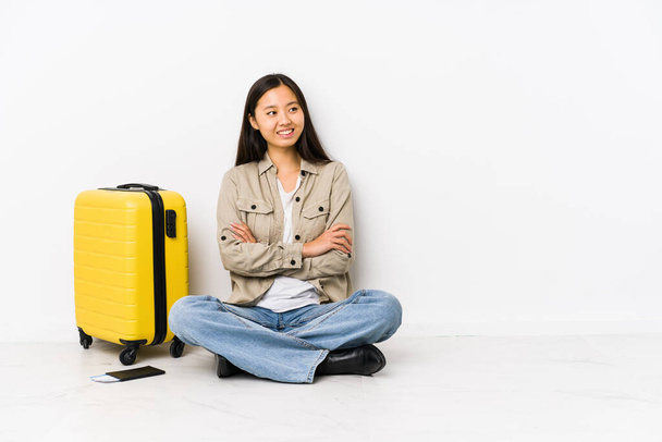 Mladý čínský cestovatel žena sedí drží palubní vstupenky s úsměvem se zkříženými pažemi. - Fotografie, Obrázek