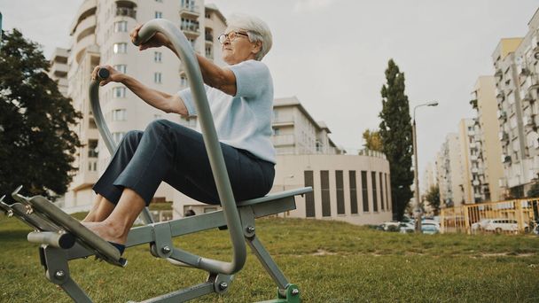 Concepto de bienestar. Ejercicio para mujeres mayores utilizando el equipo de un gimnasio al aire libre - Foto, imagen