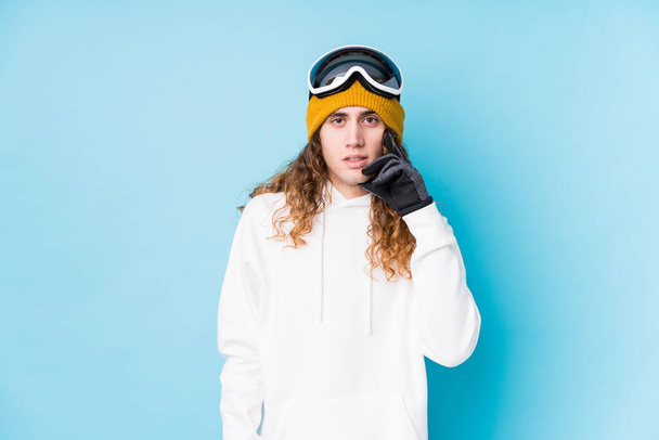 Jovem caucasiano vestindo uma roupa de esqui isolado mordendo unhas, nervoso e muito ansioso. - Foto, Imagem