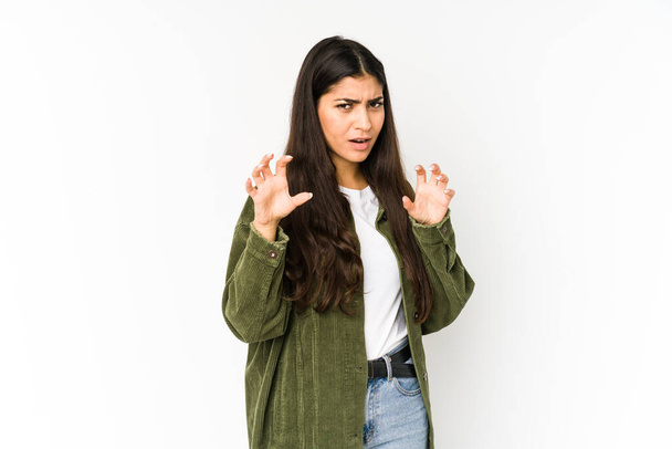 Young indian woman isolated on purple background showing claws imitating a cat, aggressive gesture. - Foto, imagen