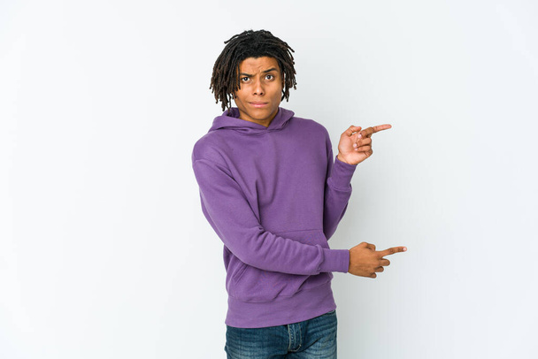 Молодий афроамериканець раста шокований вказівним пальцем на копіювальний простір.. - Фото, зображення