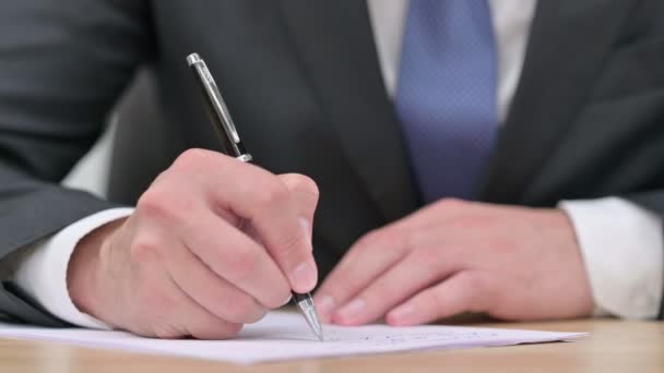 Закрыть руки бизнесмена, пишущего на бумаге  - Кадры, видео