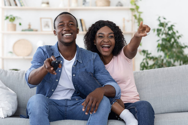 Emocjonalny Afrykanin mężczyzna i kobieta oglądają telewizję w domu - Zdjęcie, obraz