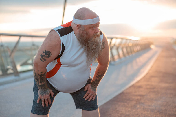 太った白人髭と大胆な男は朝の運動をしている彼の体重を減らすために - 写真・画像