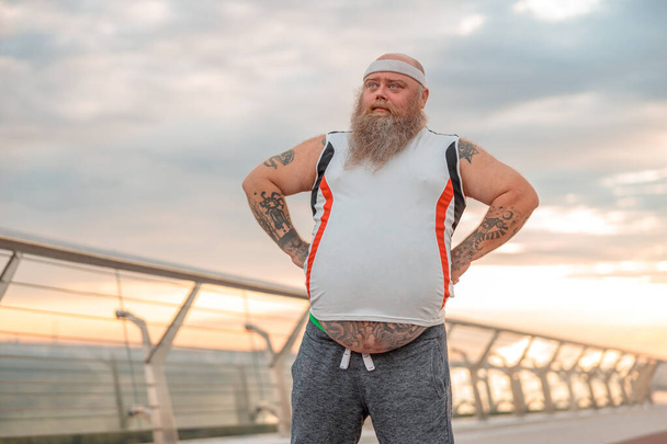Kövér kaukázusi szakállas és merész férfi reggeli erőfeszítéseket tesz, hogy lefogyjon. - Fotó, kép