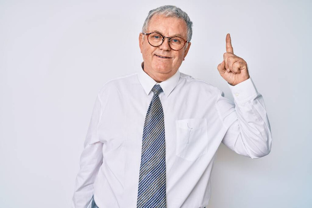 Älterer grauhaariger Mann in Businesskleidung zeigt mit erhobenem Zeigefinger auf erfolgreiche Idee. aufgeregt und glücklich. Nummer eins.  - Foto, Bild