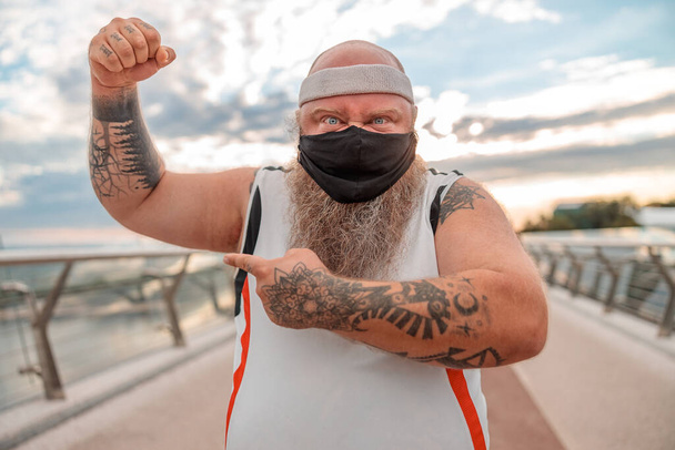 Fat caucasian bearded and bold man is doing morning exercses to loose his weight - Photo, Image