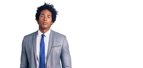 Handsome african american man with afro hair wearing business jacket looking sleepy and tired, exhausted for fatigue and hangover, lazy eyes in the morning.  - Фото, изображение