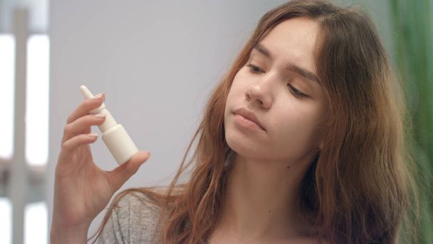 Młoda kobieta czuje zatkany nos podczas alergii i rozpylania aerozolu do nosa - Zdjęcie, obraz