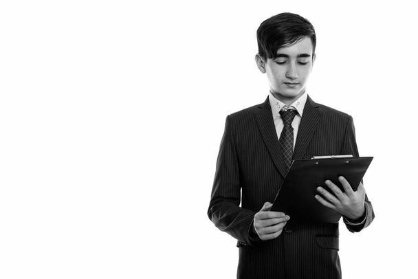 Στούντιο πλάνο του νεαρού όμορφου Πέρση έφηβο αγόρι ως επιχειρηματίας φορώντας κοστούμι σε μαύρο και άσπρο - Φωτογραφία, εικόνα