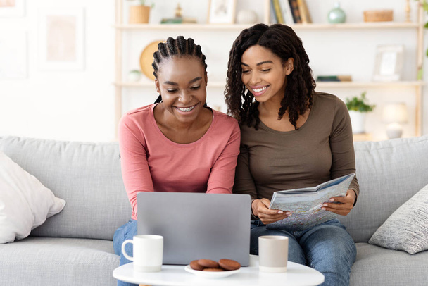 Meninas negras felizes verificando hotéis on-line, usando laptop - Foto, Imagem