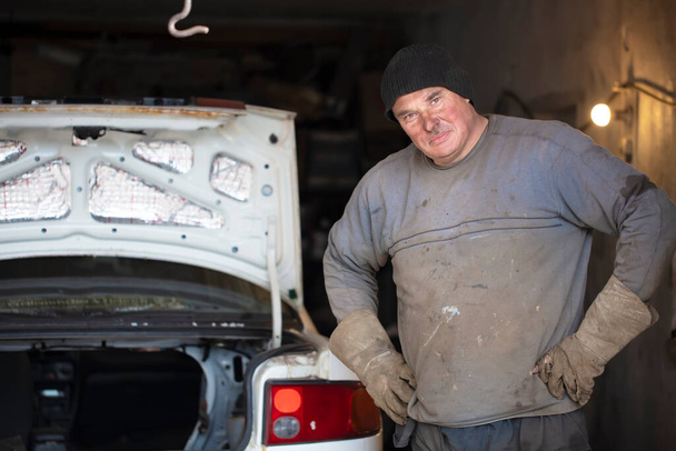 Samec automechanik ve špinavém oblečení v garáži. - Fotografie, Obrázek