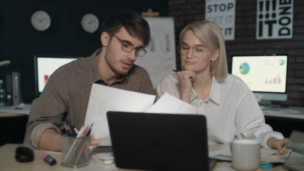 Couple d'affaires travaillant ensemble avec l'ordinateur portable avant de données de document dans le bureau de nuit - Photo, image