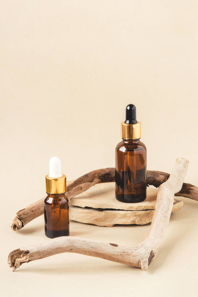 Two brown bottles of cosmetics on a natural beige background. - Foto, Bild