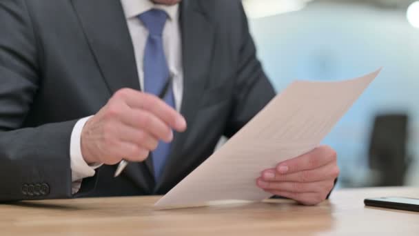 Κοντινό πλάνο του χέρια του επιχειρηματία ανάγνωση εγγράφων  - Πλάνα, βίντεο