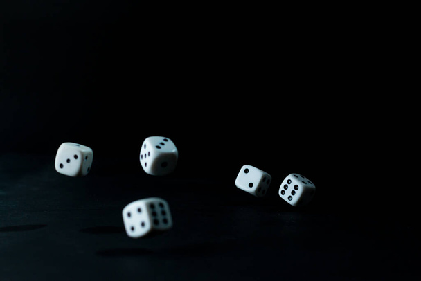 Dice rolling on the table on a black background - Photo, Image